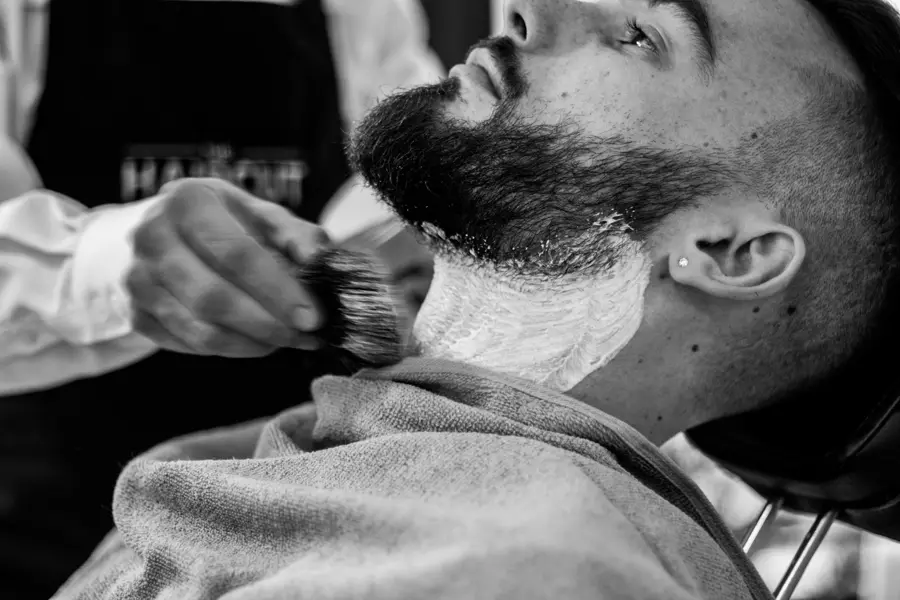 Barbero aplicando espuma en la barba de un cliente