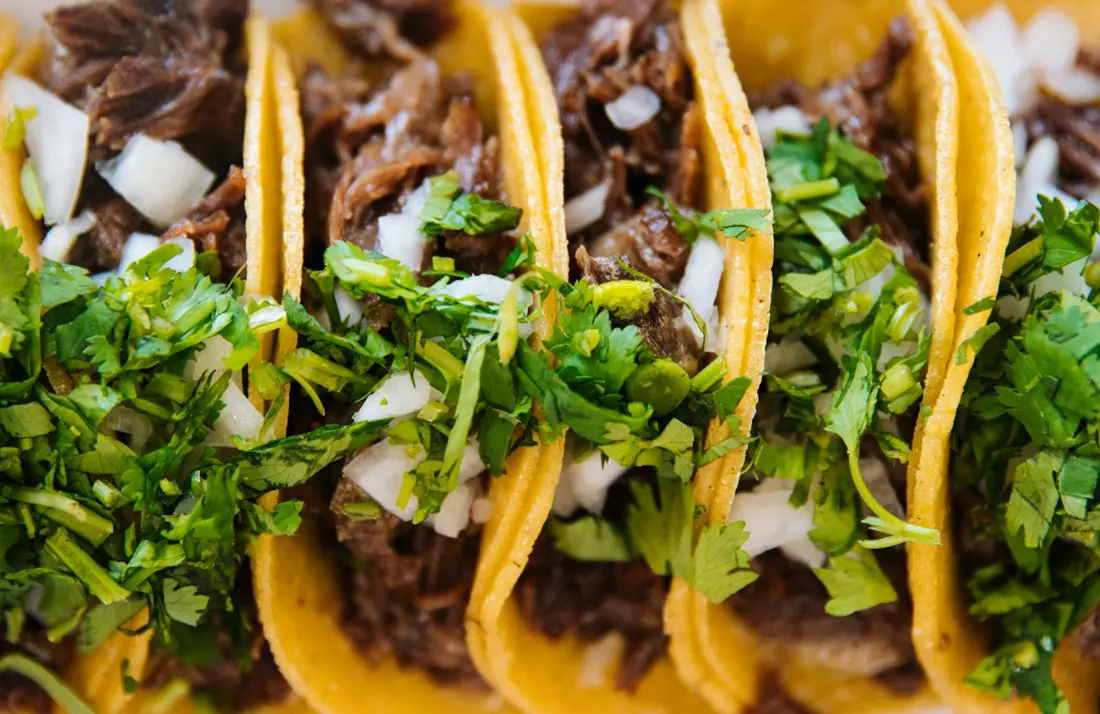 Tacos con carne, cebolla y cilantro, vistos de cerca